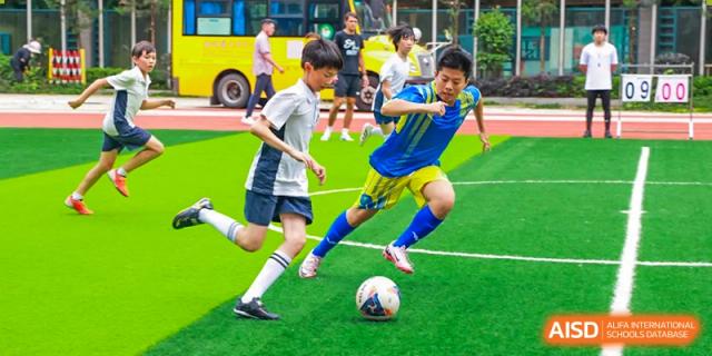 A student kicking a soccer ball on a green field during a game at Fuzhou Lakeside International School.