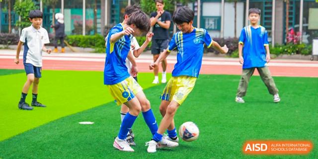 Students playing soccer on a green field at Fuzhou Lakeside International School.