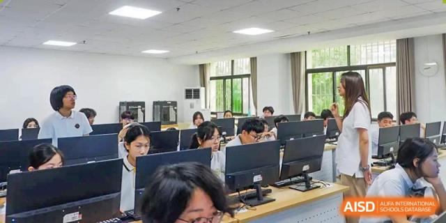 A computer lab at Grand International School filled with students working on desktop computers.