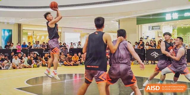 Two Grand International School students or players competing in an indoor basketball game.