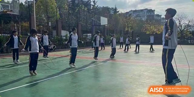Grand International School students playing a casual game of basketball on an outdoor court.