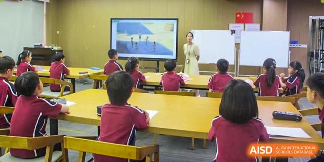 A teacher at HAILIANG FOREIGN LANGUAGE SCHOOL instructs a class, with a digital display showing a presentation.