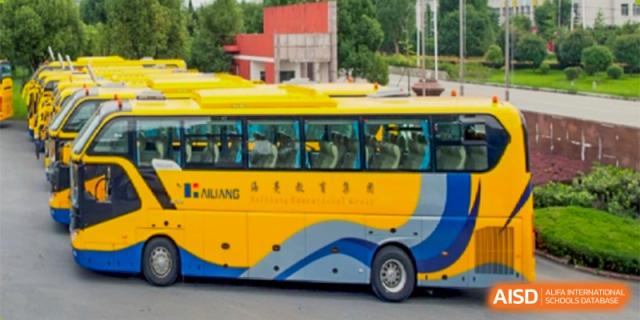 A school bus from HAILIANG FOREIGN LANGUAGE SCHOOL is parked on a street outside.