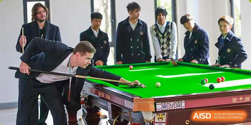 Students at HAILIANG FOREIGN LANGUAGE SCHOOL play pool in a recreation room.