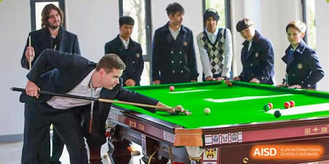 Students at HAILIANG FOREIGN LANGUAGE SCHOOL play pool in a recreation room.