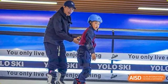 An instructor helps a young student at HAILIANG FOREIGN LANGUAGE SCHOOL with ice skating.