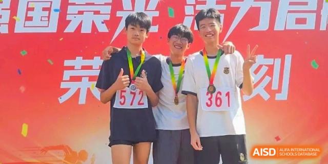Three students from HAILIANG FOREIGN LANGUAGE SCHOOL smile and proudly display their medals.