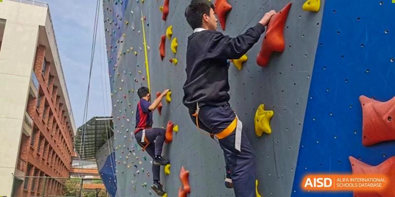 Students at HAILIANG FOREIGN LANGUAGE SCHOOL participate in a rock climbing activity.