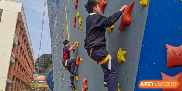 Students at HAILIANG FOREIGN LANGUAGE SCHOOL participate in a rock climbing activity.