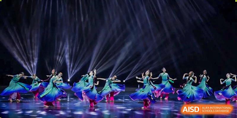 Students at HAILIANG FOREIGN LANGUAGE SCHOOL perform a traditional dance on a stage with special lighting.