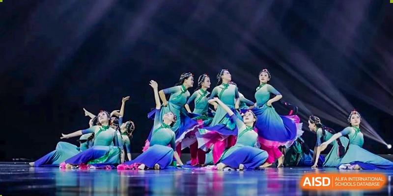A group of students at HAILIANG FOREIGN LANGUAGE SCHOOL performs a synchronized dance on a stage.
