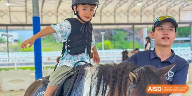 A student at HAILIANG FOREIGN LANGUAGE SCHOOL practices horse riding while wearing a helmet and protective vest.
