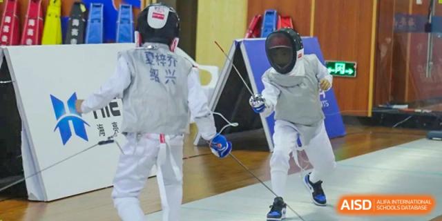 Students from HAILIANG FOREIGN LANGUAGE SCHOOL practice fencing with foils, masks, and protective jackets.