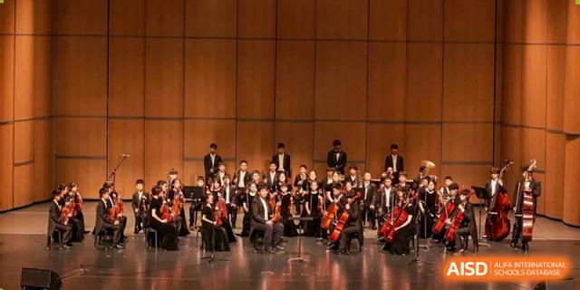 Students from HAILIANG FOREIGN LANGUAGE SCHOOL play instruments together during an orchestra performance.