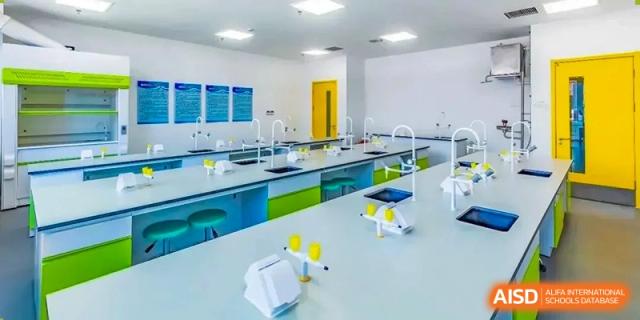 A bright science laboratory with blue and yellow lab benches and equipment at HD Qingdao School.