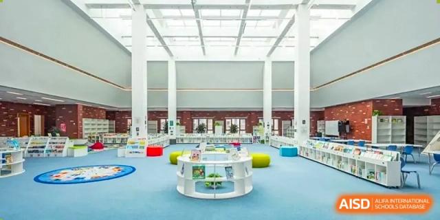 A colorful library or study area with circular shelves and soft seating at HD Qingdao School.