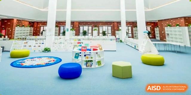 A reading corner with various-sized blue poufs and colorful cubes at HD Qingdao School.