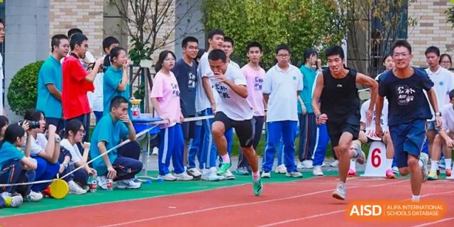 Students from Hongyi Cambridge International School (HYCIS) lined up for a race, with one student running from the starting line on the track.