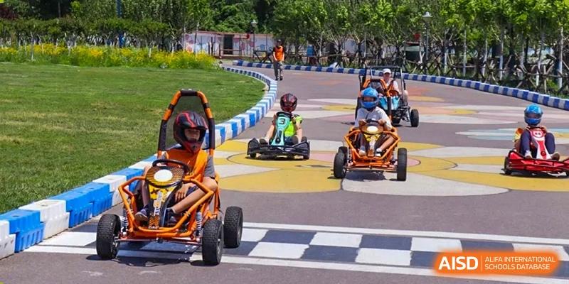 Students in go-karts race on an outdoor track at the International School of Qingdao.