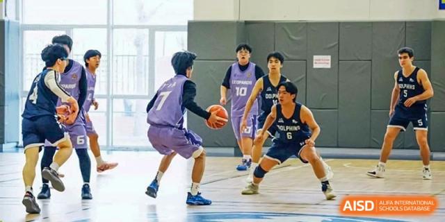 A basketball player dribbles the ball on the court at the International School of Qingdao.