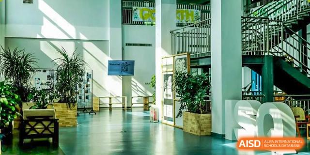 A bright and open indoor hallway with large windows at the International School of Qingdao.