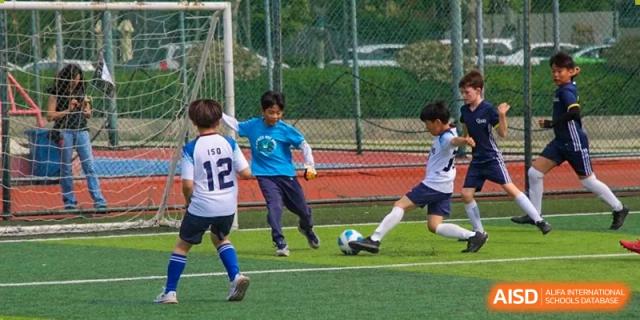 A student kicks a soccer ball down the field during a game at the International School of Qingdao.
