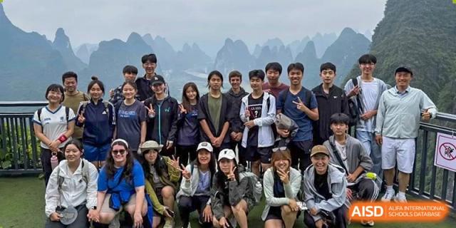Students pose for a group photo while on a trip at the International School of Qingdao.