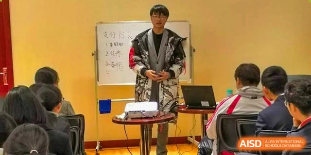 A teacher presenting in front of a whiteboard in a classroom setting at the International Department of Kunming No.10 Middle School.