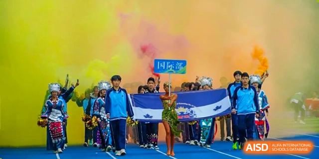 Students carrying a banner during a colorful parade at a sports event for the International Department of Kunming No.10 Middle School.