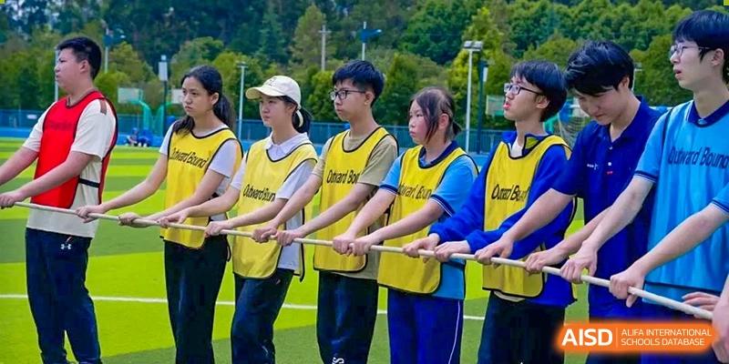 Students participating in a tug-of-war competition on the field at the International Department of Kunming No.10 Middle School.
