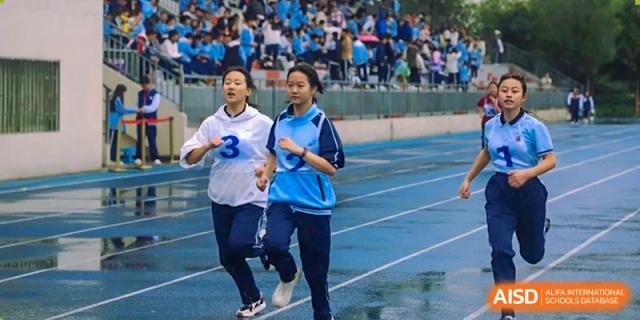 Two female students running on the track during a race at the International Department of Kunming No.10 Middle School.