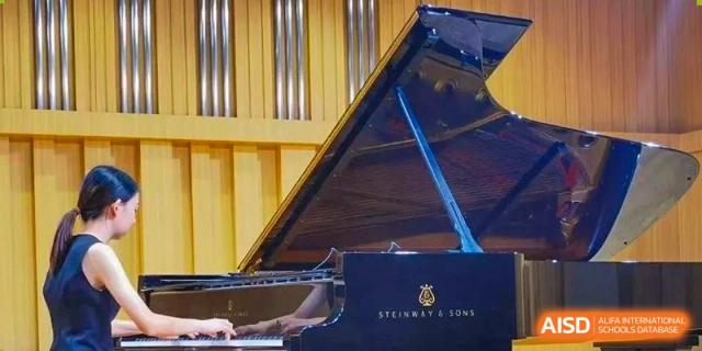 A close-up view of a Steinway grand piano on a stage at an event for the International Department of Kunming No.10 Middle School.