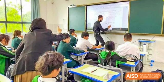 A teacher giving instructions to students in a classroom at Kunming World Youth Academy.
