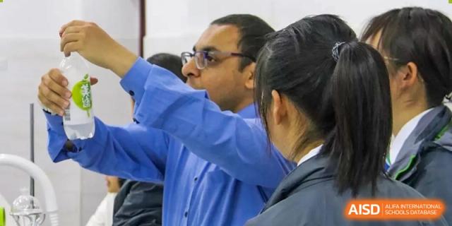 A teacher guiding a student during a science experiment at Kunming World Youth Academy.