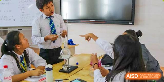A teacher pointing to a lab setup during a science class at Kunming World Youth Academy.