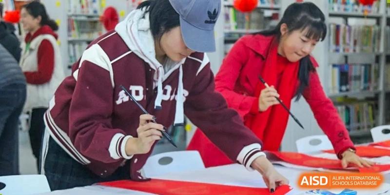 Students in hoodies working together on a project at Kunming World Youth Academy.