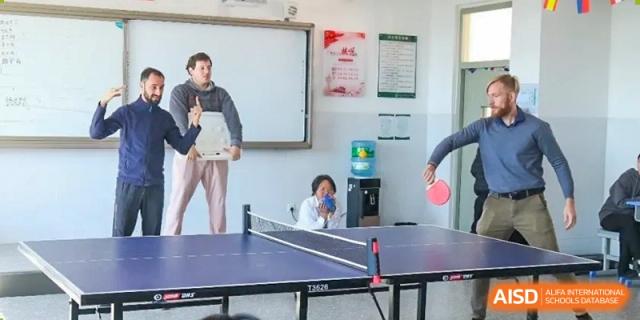 A student playing table tennis in a game room at Kunming World Youth Academy.
