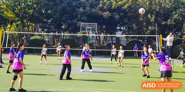 Students playing basketball on an outdoor court at Kunming World Youth Academy.