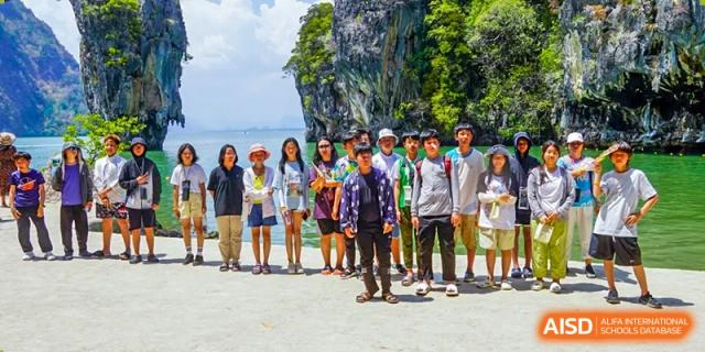 Students standing together with a rocky cliff in the background at Kunming World Youth Academy.