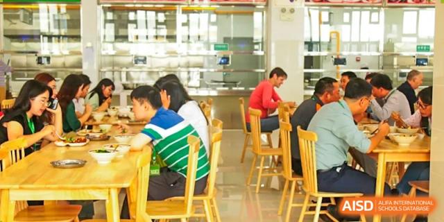 Students eating in the school cafeteria at Kunming World Youth Academy.