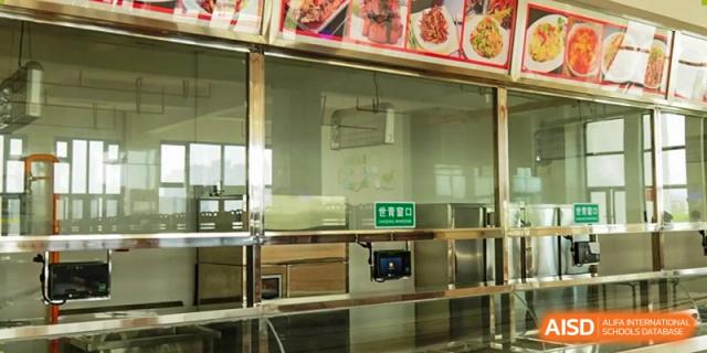 A view of the school cafeteria with a clean food service counter at Kunming World Youth Academy.