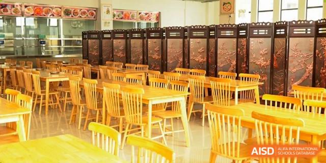 A section of the school cafeteria with tables and chairs at Kunming World Youth Academy.