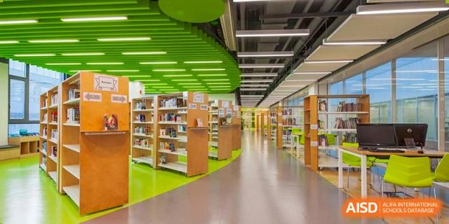 A bright, modern library at Lycée Français de Shanghai is shown with bookshelves and a comfortable sitting area.