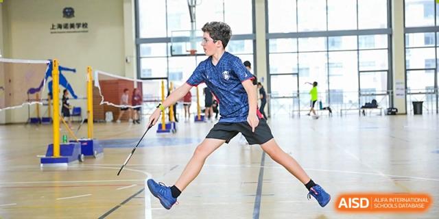 A Lycée Français de Shanghai student is playing badminton in a sports hall.
