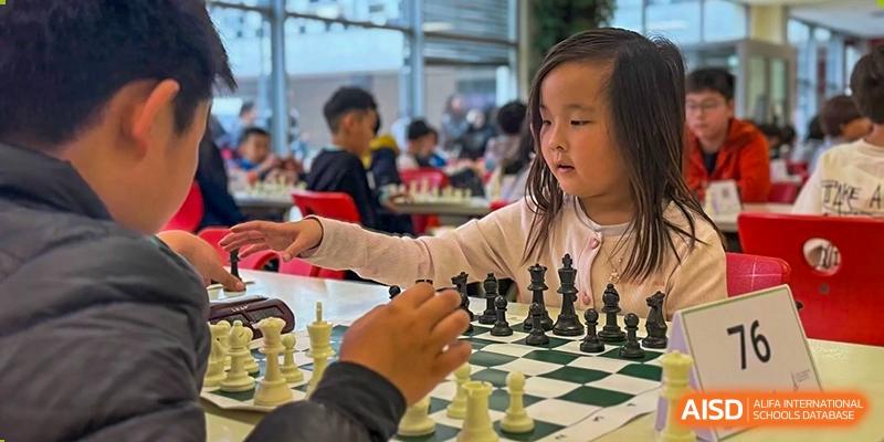 A young Lycée Français de Shanghai student is playing a game of chess.