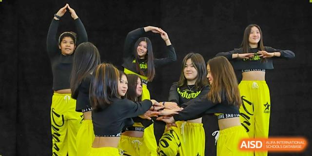 A group of female Lycée Français de Shanghai students is practicing a dance routine together.