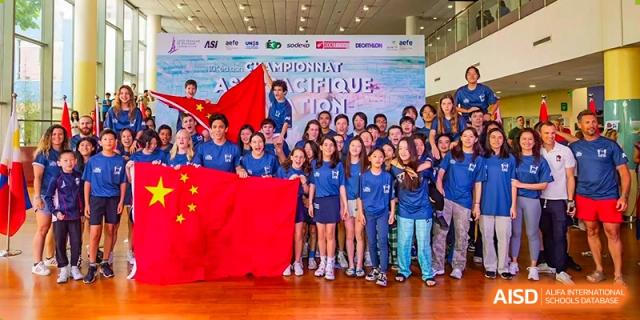 A large group of Lycée Français de Shanghai students is posing for a photo at a school event.
