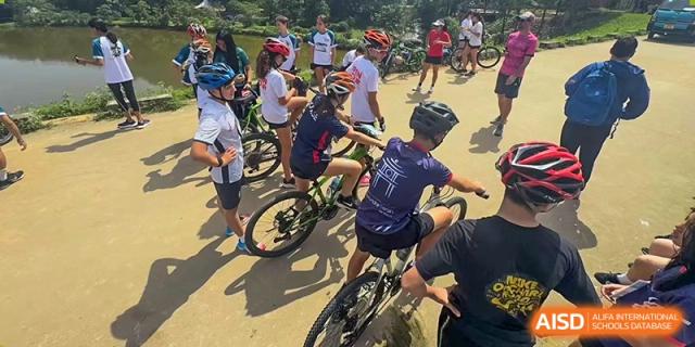 A group of Lycée Français de Shanghai students is riding bikes on a path.