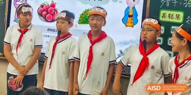 Two male students in red scarves and white shirts standing outside, smiling for a portrait at Maple Leaf School- Xiangyang.