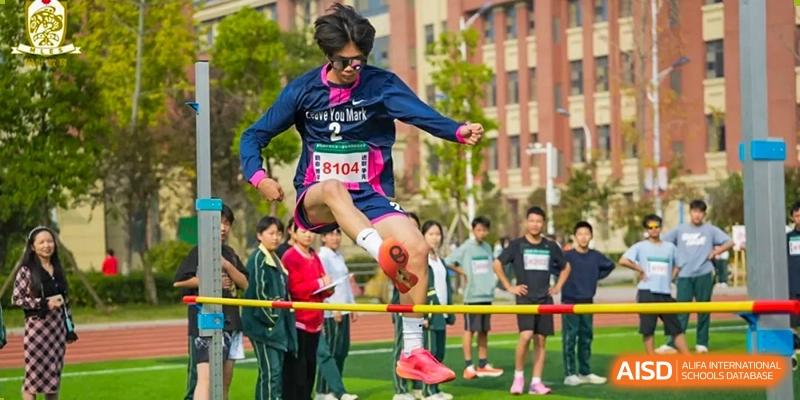 A male student from Maple Leaf School - Xiangyang participating in the high jump event during a track and field competition.
